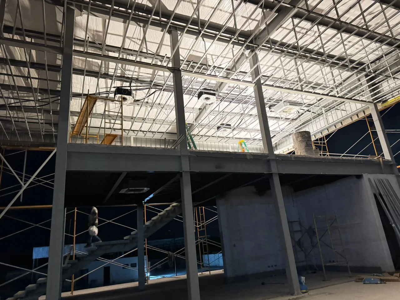 Shacman dealership interior under construction with air-conditioning units beneath the roof framing
