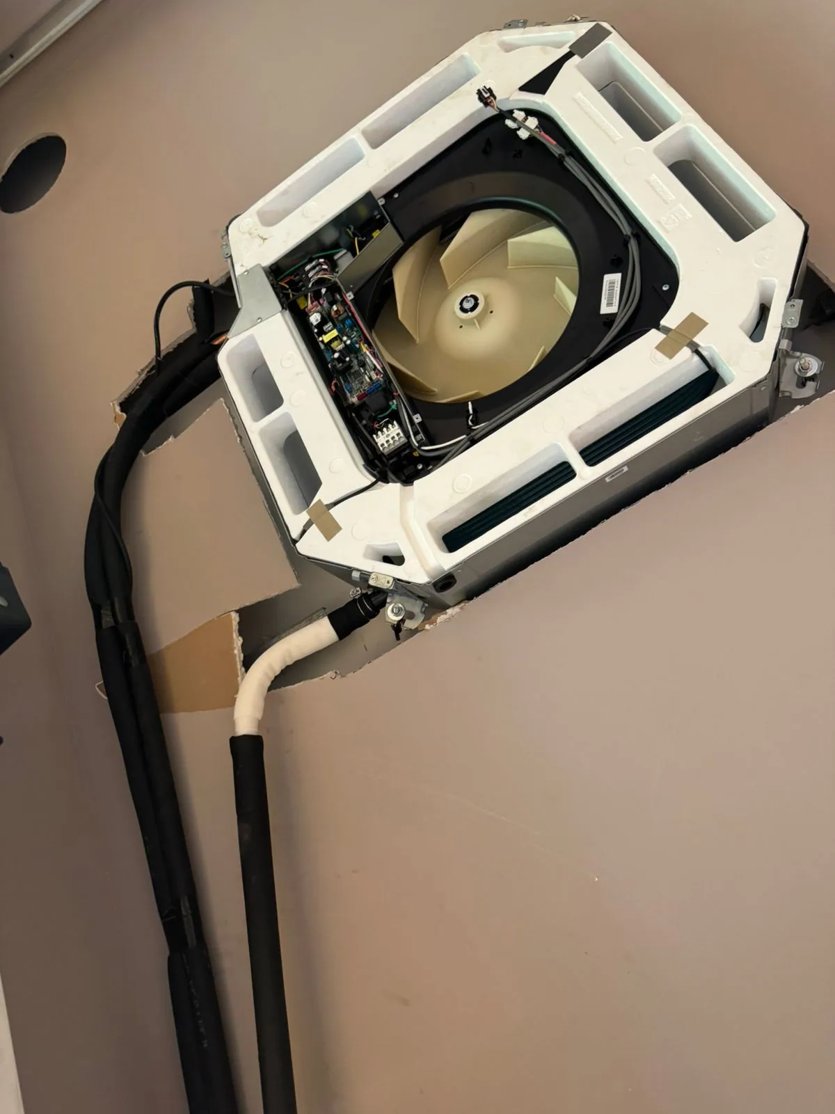 Ceiling cassette unit with its panel open and internal components visible