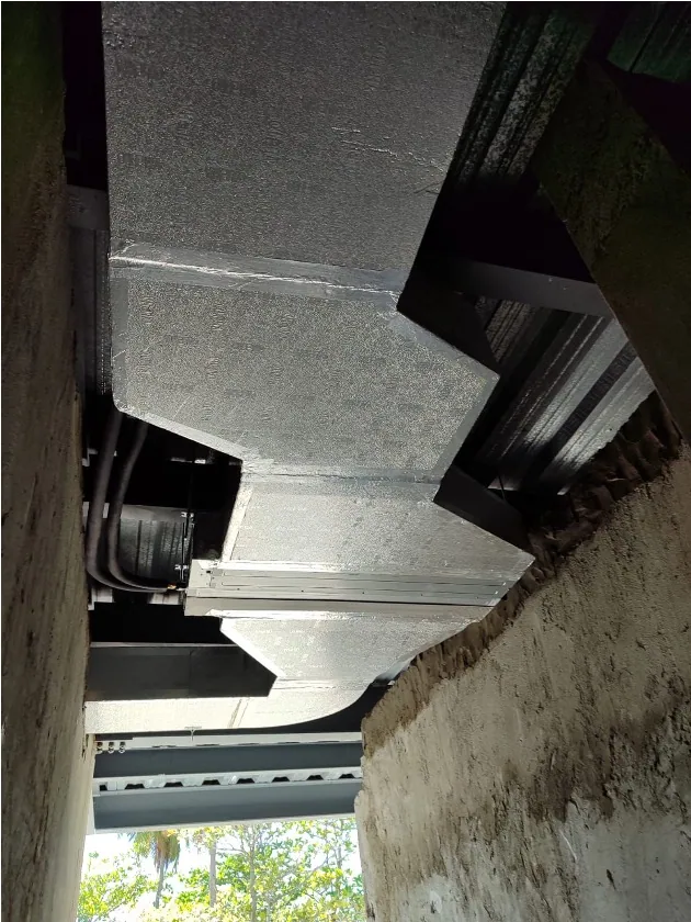 Exposed metal ducts beneath the ceiling of an unfinished interior space