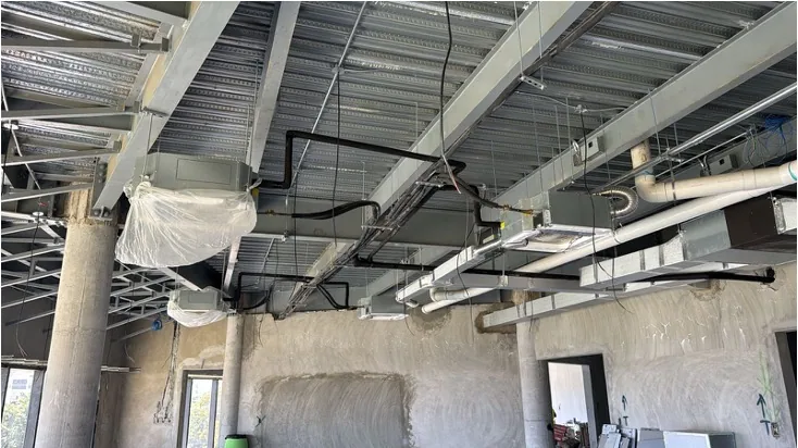 Open ceiling revealing ductwork and interior structural elements