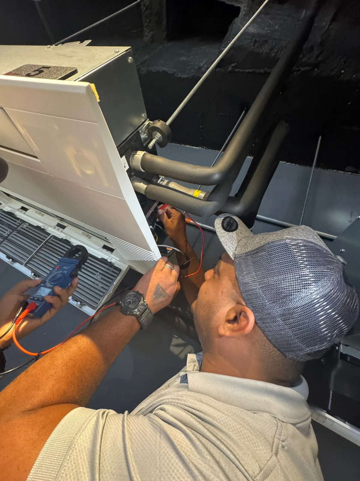 Hands-on inspection of a climate-control unit with a measuring instrument during training