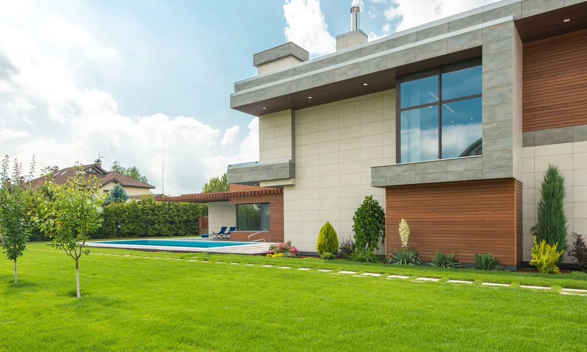 Casa moderna con jardín, como referencia para planificar climatización residencial