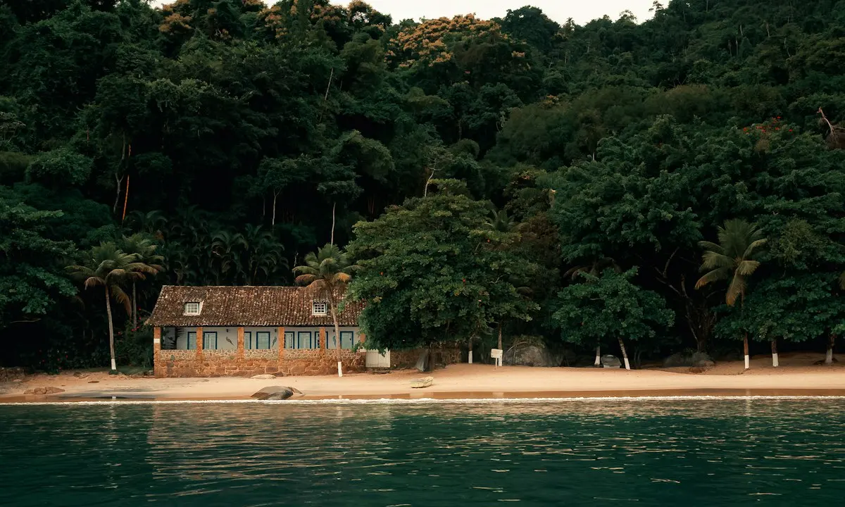 Casa junto al mar con vegetación tropical detrás