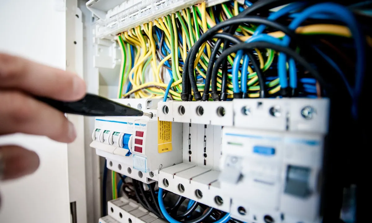 Work on an electrical panel with circuit breakers and wiring