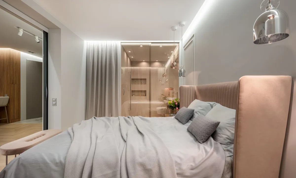 Bright bedroom with a bed beside large windows
