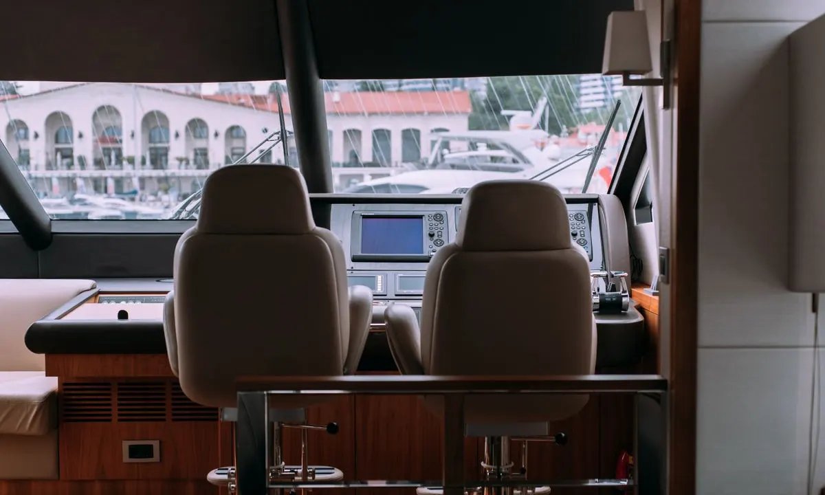 Interior helm of a yacht with a view of a marina