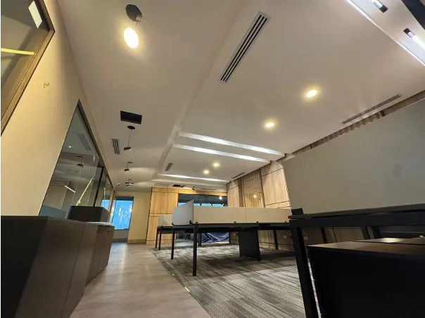 Office interior with linear diffusers integrated into the ceiling